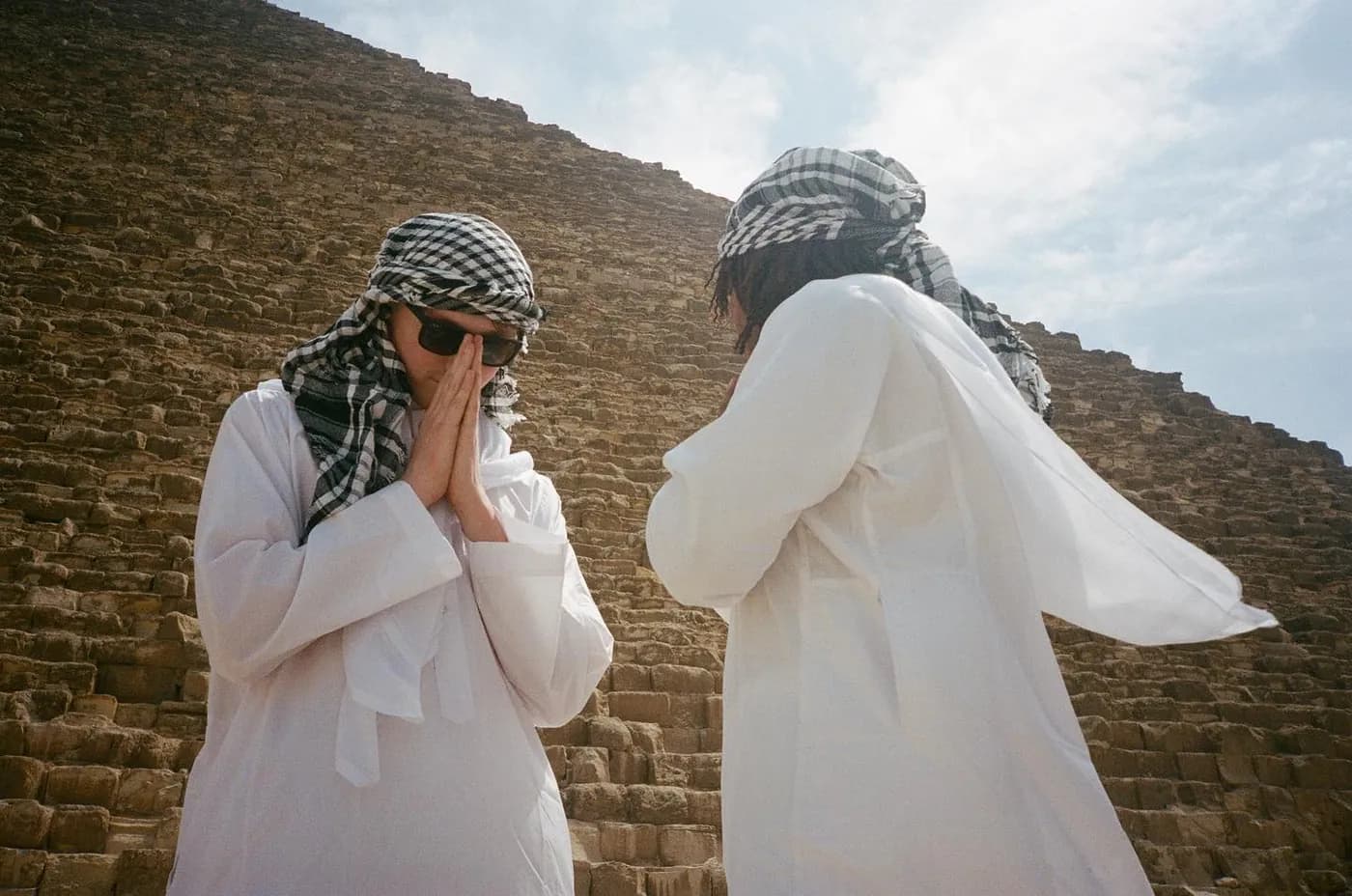 Two in white in front of a pyramid