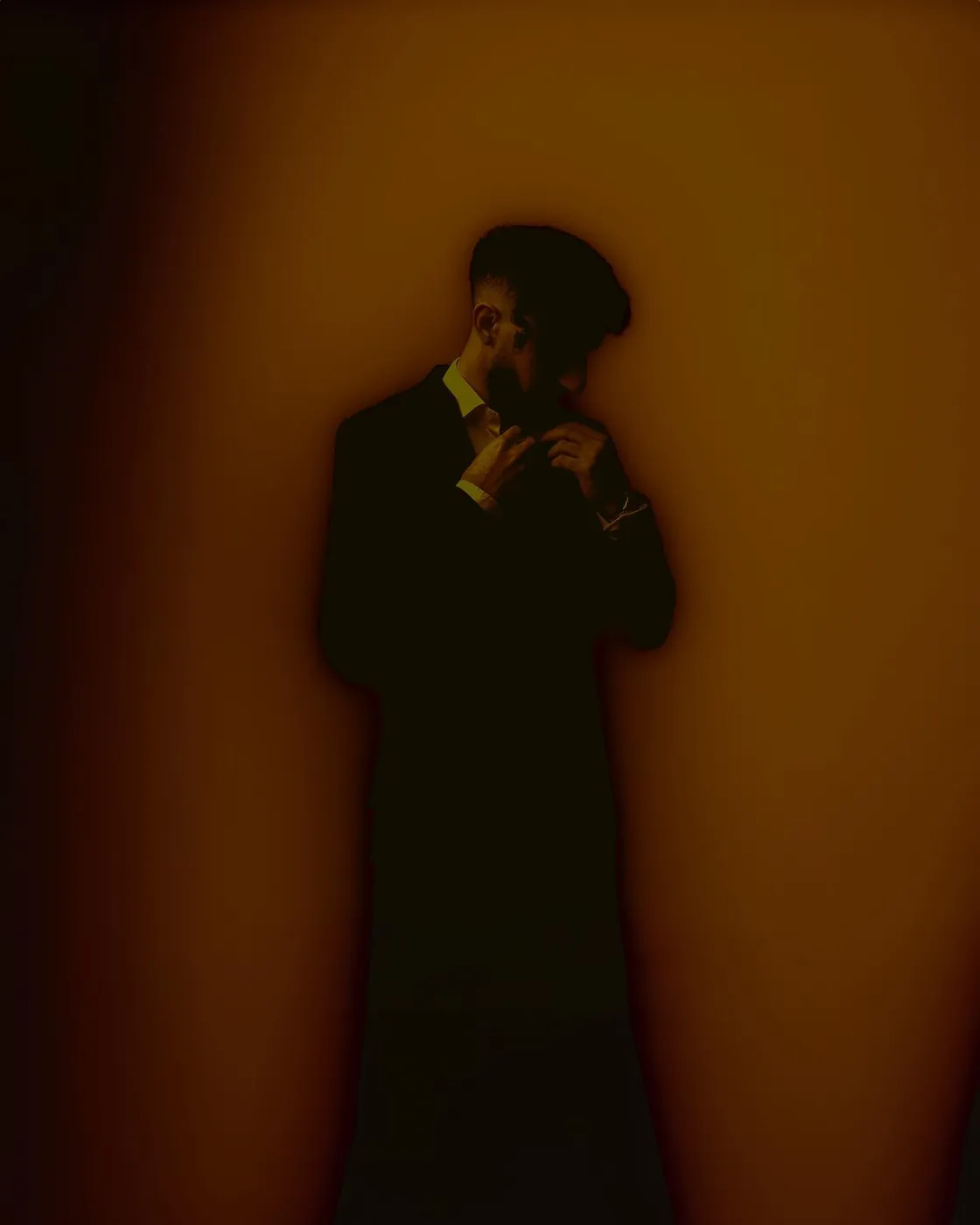 In dark, warm light, with a phone